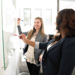 Healthcare professionals collaborating during a PET-CT training session, discussing imaging techniques and best practices on a whiteboard in a modern office setting