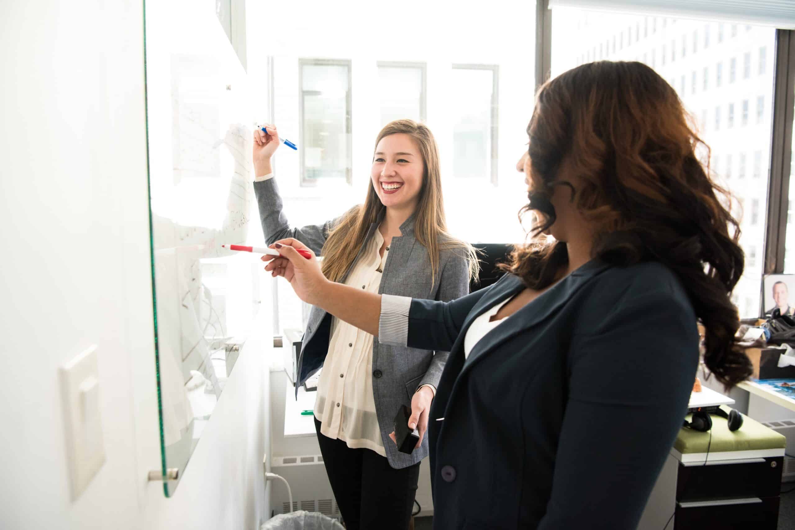 Healthcare professionals collaborating during a PET-CT training session, discussing imaging techniques and best practices on a whiteboard in a modern office setting