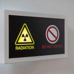 Illustration of radiological safety procedures for decontaminating radioactive spills, featuring protective equipment and radiation hazard indicators.