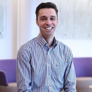 Effervescent young man smiling during a training session at The Christie PET-CT Academy, highlighting professional development in advanced medical imaging techniques.